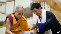 Lobsang Sangay, PM Pemerintah Tibet di pengasingan (kanan) menyerahkan dokumen kepada pemimpin spiritual Tibet, Dalai Lama di Sekolah Pedesaan Anak-anak di wilayah Dharmsala, India (5/6).