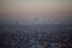 FILE - Mexico's new climate law promises to reduce greenhouse gas emissions by 30% by 2020, which should make a difference in Mexico City, among the most polluted cities in the world.