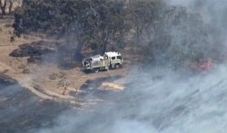 An aerial scene shows firefighters extinguishing wildfires in the Adelaide Hills, Australia, Dec. 24, 2019, in this image made from video.