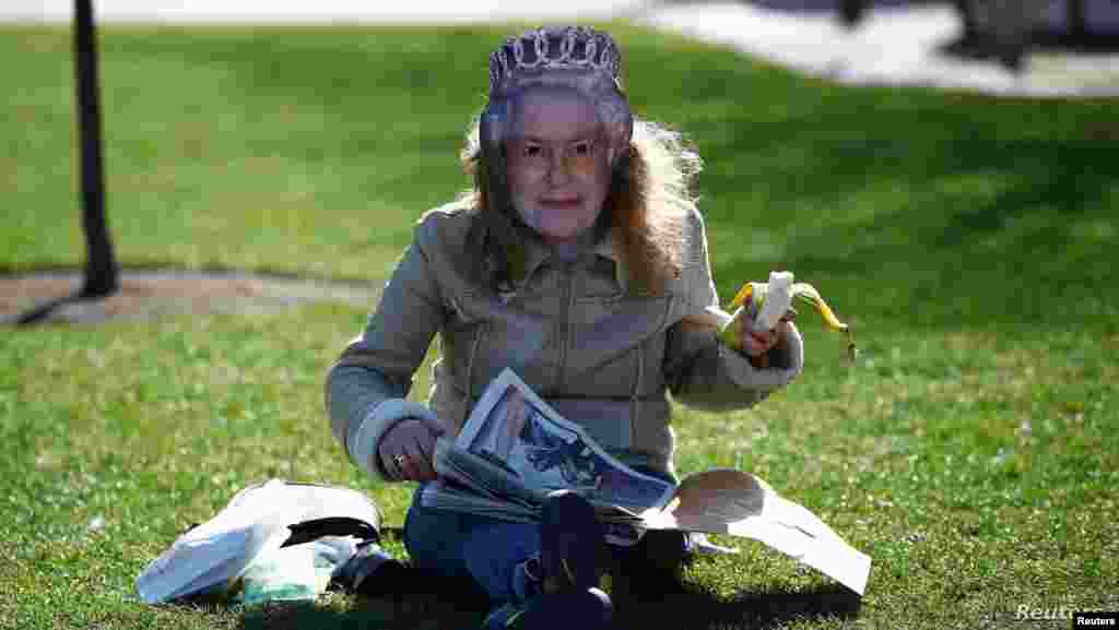 영국 런던에서 시민이 엘리자베스 영국 여왕의 마스크를 착용한 채 신문을 읽고 있다. 