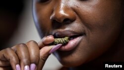 Seorang pelanggan, Gosiame Makoe, mencicipi cacing Mopane di Restoran Insect Experience di Cape Town, Afrika Selatan, 23 Agustus 2019. (Foto: Reuters)