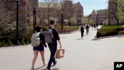 FILE - Students walk on the campus of Boston College, April 29, 2024, in Boston.