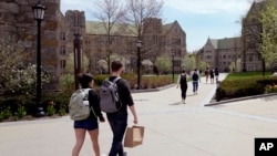 FILE - Students walk on the campus of Boston College, April 29, 2024, in Boston. 