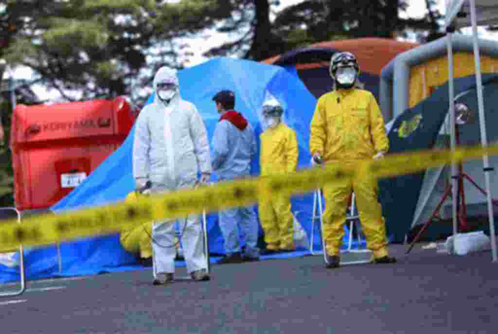Oficiales del departamento de incendios rodean el área de la central de Fukushima.
