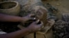 Un potier utilise de la boue pour mouler un visage dans une usine de poterie près des rives du Nil, à Alqamayir, Omdurman, Soudan, le 18 février 2020.