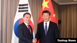 Presiden China Xi Jinping (kanan) bersama Presiden Korea Selatan Moon Jae-in (Foto: dok). Kedua pemimpin dijadwalkan akan bertemu di sela-sela pertemuan APEC di Vietnam, 10-11 November 2017. 