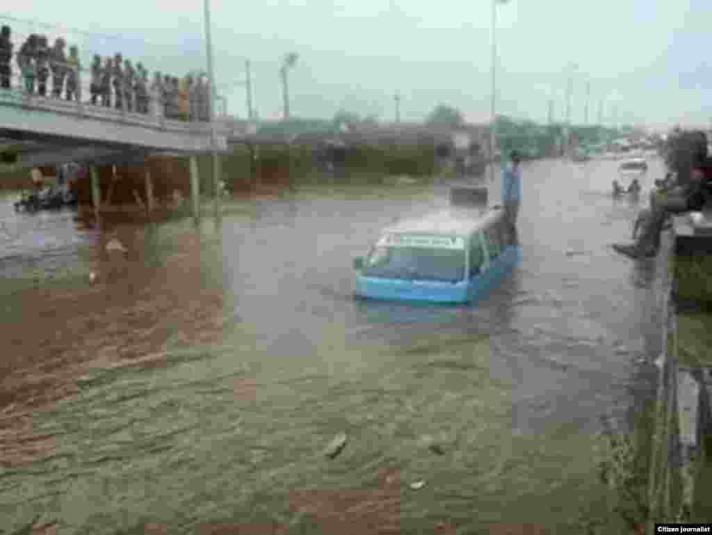 Táxi parado no meio de uma estrada de Luanda inundada devido às chuvas. 