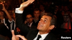 FILE - Former French President Nicolas Sarkozy leaves a restaurant in Paris, July 2, 2014.