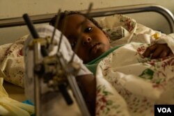 Samwarit, 4, lies on her hospital bed recovering from knife wounds in her leg and a gunshot in her hand, according to her father, in Mekelle, Ethiopia, June 4, 2021. (Yan Boechat/VOA)