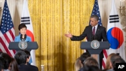 President Barack Obama gestures toward South Korean President Park Geun-hye during their joint news conference in the East Room of the White House in Washington, Friday, Oct. 16, 2015. (AP Photo/Pablo Martinez Monsivais)