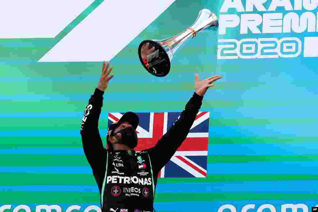 Mercedes driver Lewis Hamilton of Britain throws his trophy after the Formula One Grand Prix at the Barcelona Catalunya racetrack in Montmelo, Spain.