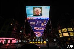 FILE - An outdoor screen in Beijing shows a news program following the death of former US secretary of state Henry Kissinger on November 30, 2023. China on November 30 hailed the late Henry Kissinger as an "old friend" for helping to establish ties between Beijing and Washington.