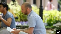 Iraq War veteran Kristofer Goldsmith sits in a campus park after his last final exam of the semester at Columbia University in New York, May 9, 2018.