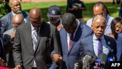 George Floyd's brothers Philonise, left, and Terrence, center, nephew Brandon Williams, right, and the Rev. Al Sharpton (foreground) pray after the sentencing of former Minneapolis police officer Derek Chauvin, in Minneapolis, June 25, 2021.
