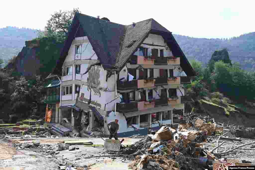 A worker clears debris outside the destroyed guest house 'Jaegerstuebchen' in Laach, part of the municipality of Mayschoss, district of Ahrweiler, western Germany, July 23, 2021, a week after heavy rain and&nbsp;floods in the Ahr region. Western Europe was hit by devastating floods, leaving at least 209 people dead in Germany and Belgium, as well as dozens missing.