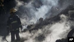 An Israeli firefighter takes a break as he fights a blaze in the youth village (boarding school) of Yemin OrdE, near the northern city of Haifa, Israel, 05 Dec 2010