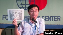 Masaru Sato, Assistant Press Secretary at the Japanese Ministry of Foreign Affairs, holding a 16th-century map of Korea to explain Japan's claim to the island of Takeshima, August 22, 2012. (VOA/Miguel Quintana)