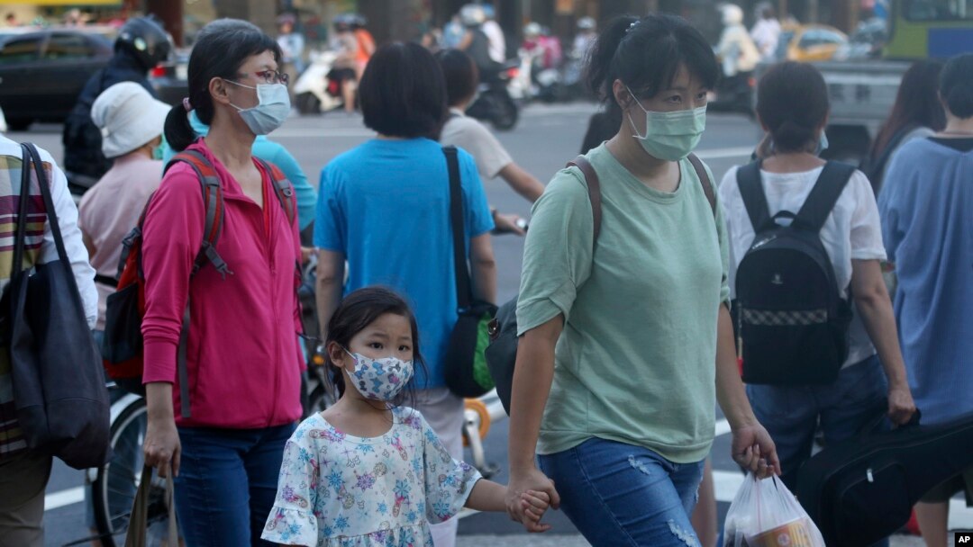 台湾台北街道上的行人戴着口罩预防新冠病毒。（2020年7月28日）