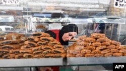 FILE—An employee serves pastry to a customer at a bakery in Tunis during the Muslim holy fasting month of Ramadan on March 29, 2024, amid a shortage of sugar supplies in the country.