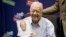 FILE - Former President Jimmy Carter poses for photographs with a copy of his new book "A Full Life: Reflections at Ninety," July 10, 2015, at the Free Library in Philadelphia, Pennsylvania. 