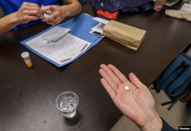 Dr. Shelly Tien hands a patient the initial abortion inducing medication at Trust Women clinic in Oklahoma City, U.S., December 6, 2021. (REUTERS/Evelyn Hockstein)