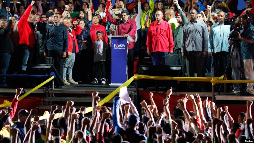 Venezuela's President Nicolas Maduro raises a finger as he is surrounded by supporters while speaking during a gathering after the results of the election were released, outside of the Miraflores Palace in Caracas, Venezuela, May 20, 2018. 