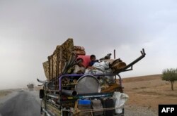 FILE - Displaced Syrians from Deir el Zour head to refugee camps on the outskirts of Raqa, Sept. 24, 2017.