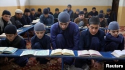 Sejumlah siswa laki-laki membaca Al-Qur'an di sebuah madrasah di Kabul, Afghanistan, pada 18 April 2021. (Foto: Reuters/Omar Sobhani)