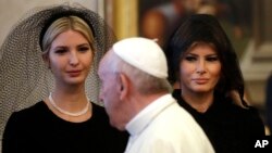 Ivanka Trump (kiri) dan Melania Trump ketika bertemu Paus Fransiskus di Vatikan, Rabu (24/5). Melania Trump (kanan) mengenakan kerudung hitam atau "mantila", aturan bagi perempuan untuk bertemu Paus yang disyaratkan oleh Vatikan. 