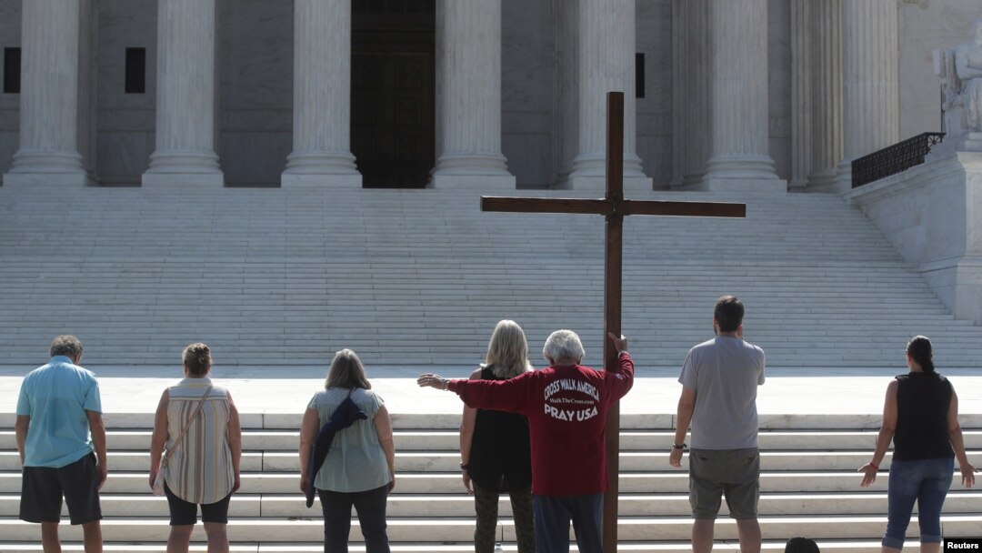 Demonstrators gather outside the U.S. Supreme Court as the court ruled that religious institutions like churches and schools are shielded from employment discrimination lawsuits in Washington, July 8, 2020. 