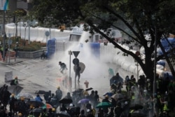 Anti-government protesters are sprayed by water cannon during a demonstration near Central Government Complex in Hong Kong, Sept. 15, 2019.
