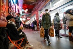 Shoppers wait in a line stretching outside of a Trader Joe's supermarket, March 12, 2020, in the Brooklyn borough of New York.