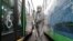 A worker wearing a protective suit sprays disinfectant as a precaution against the coronavirus at a bus garage in Seoul, South Korea, Feb. 26, 2020. 
