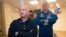 In this March 26, 2015 file photo, U.S. astronaut Scott Kelly, right, crew member of the mission to the International Space Station, stands behind glass in a quarantine room, behind his brother, Mark Kelly, also an astronaut, after a news conference (AP Photo/Dmitry Lovetsky)
