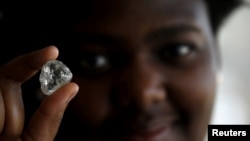 FILE- A visitor holds a diamond during a visit to the De Beers Global Sightholder Sales (GSS) in the capital Gaborone in Botswana, November 24, 2015. 