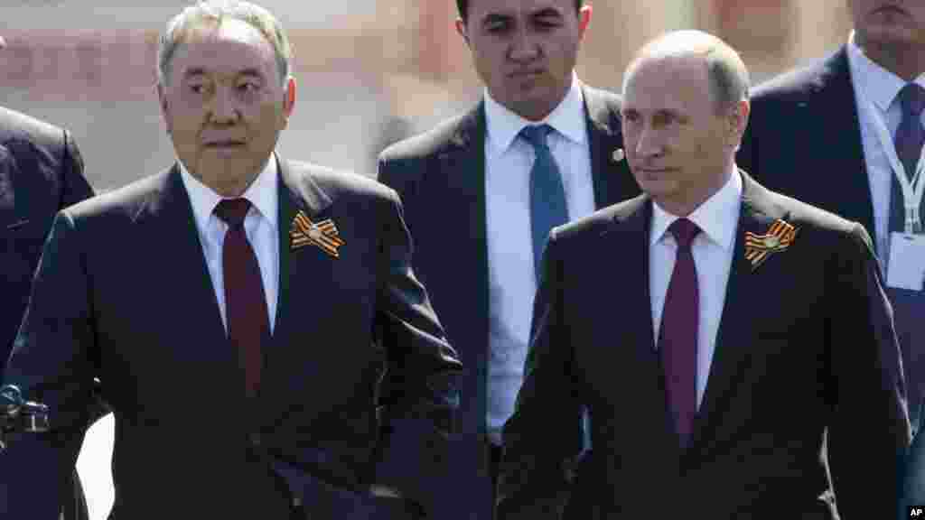 Le président russe Vladimir Poutine, à droite et le président kazakh Noursoultan Nazarbaïev, à gauche, à pied après le marquage de 71 ans après la victoire dans la Seconde Guerre mondiale sur la Place Rouge à Moscou, Russie, le lundi 9 mai 2016 parade militaire Jour de la Victoire.