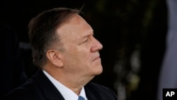 FILE - Secretary of State Mike Pompeo listens as President Donald Trump speaks during an Armed Forces welcome ceremony for the new chairman of the Joint Chiefs of Staff Gen. Mark Milley, at Joint Base Myer-Henderson Hall, Virginia, Sept. 30, 2019.