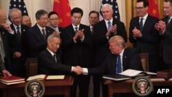 El presidente de Estados Unidos, Donald Trump, y el viceprimer ministro de China, Liu He, el principal negociador comercial de su país, se dan la mano al firmar acuerdos comerciales entre Estados Unidos y China en Washington, DC, el 15 de enero de 2020. 