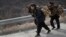 In this Feb. 19, 2016, photo, North Korean women carry firewood as they walk along a highway in Sinpyong county in North Hwanghae province, North Korea. 
