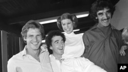FILE - From left, actors Harrison Ford, Anthony Daniels, Carrie Fisher and Peter Mayhew take a break on the set of a 1978 television special.