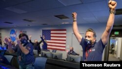 Miembros del equipo del rover Perseverance de la NASA reaccionan en el salón de control de la misión después de recibir la confirmación de que la nave espacial aterrizó con éxito en Marte el 19 de febrero de 2021.