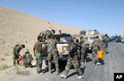 Members of Afghan security forces and volunteer militias break on their way to Kunduz, Afghanistan, to fight against Taliban militants, Oct. 1, 2015.