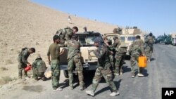 Members of Afghan security forces and volunteer militias break on their way to Kunduz, Afghanistan, to fight against Taliban militants, Oct. 1, 2015.