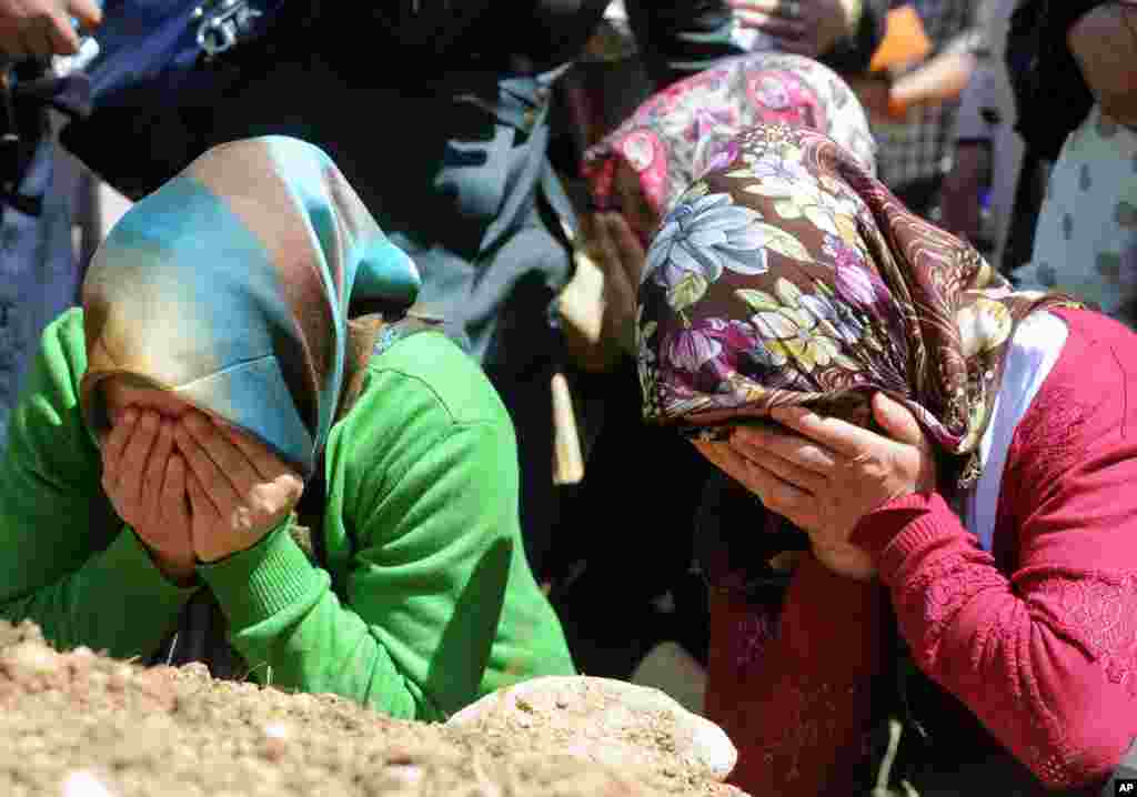 Family members cry during the funerals of mine accident victims in Soma, Turkey, Thursday, May 15, 2014.