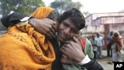 An Indian man whose two relatives died in a stampede at a railway station cries and comforts other relative as they arrive to take the bodies from a morgue, in Allahabad, India, February 11, 2013.