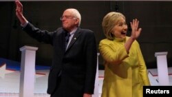 Democratic U.S. presidential candidates Senator Bernie Sanders and former Secretary of State Hillary Clinton arrive on stage ahead of the start of the PBS NewsHour Democratic presidential candidates debate in Milwaukee, Wisconsin, Feb. 11, 2016. 