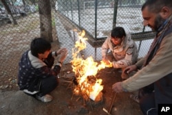 Afghan men warm themselves near a fire in Kabul, Afghanistan, Nov. 10, 2015. Extreme poverty makes difficulties for Afghans to cope with the cold winter.