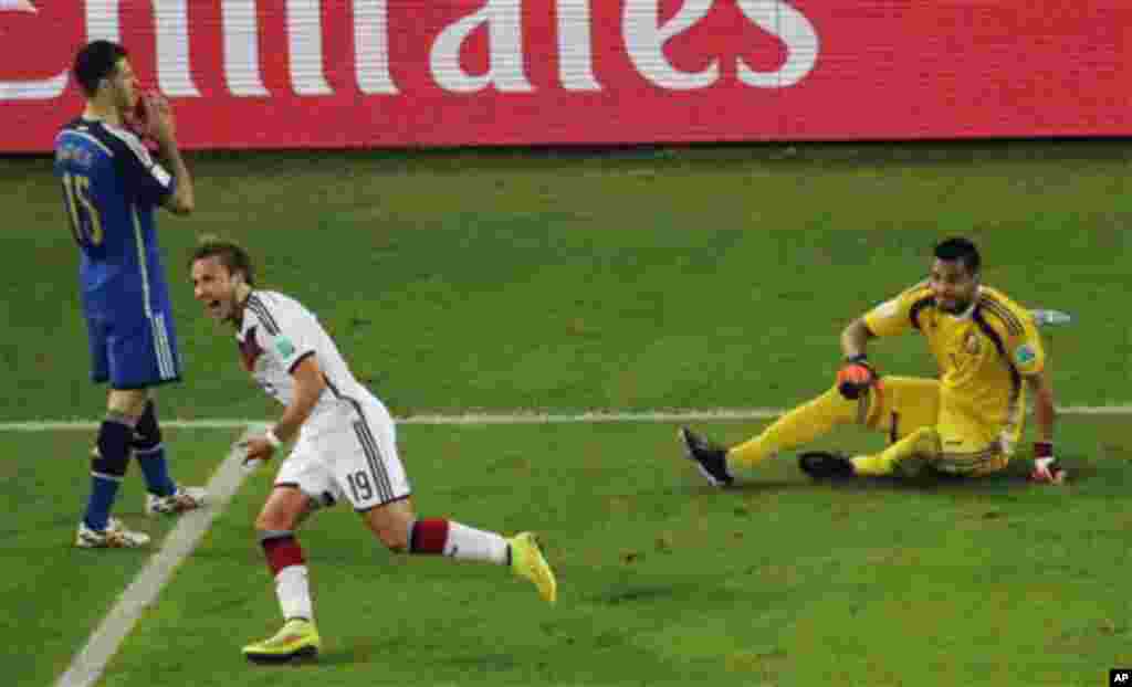 Germany's Mario Goetze celebrates past Argentina's goalkeeper Sergio Romero and Argentina's Martin Demichelis, left, after scoring his side's first goal during the World Cup final soccer match between Germany and Argentina at the Maracana Stadium in Rio d