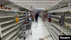 Barang-barang kebutuhan rumah tangga makin minim di rak-rak yang hampir kosong di sebuah supermarket di Washington, DC., 15 Maret 2020. (Foto: Reuters)