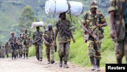 M23 rebel fighters walk as they withdraw near the town of Sake, west of Goma in eastern Congo, November 30, 2012. 